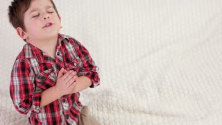 videoblocks-praying-child-little-boy-saying-prayer-before-going-to-bed-christian-kid-with-closed-eyes-sitting-on-knees-and-calling-to-god-strong-belief-in-heart-boy-holding-hands-togethe