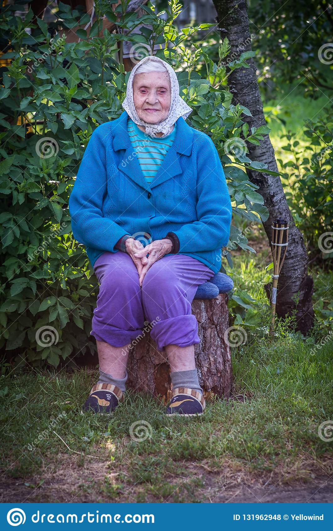 old-woman-sitting-log-very-caucasian-lady-senior-portrait-outdoors-wearing-blue-sweater-scarf-131962948