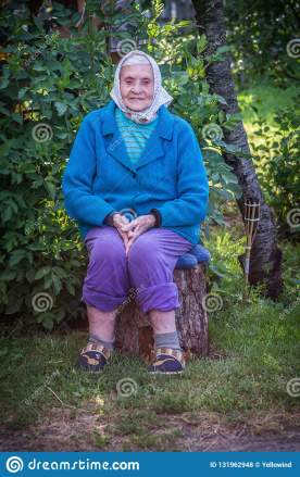 old-woman-sitting-log-very-caucasian-lady-senior-portrait-outdoors-wearing-blue-sweater-scarf-131962948