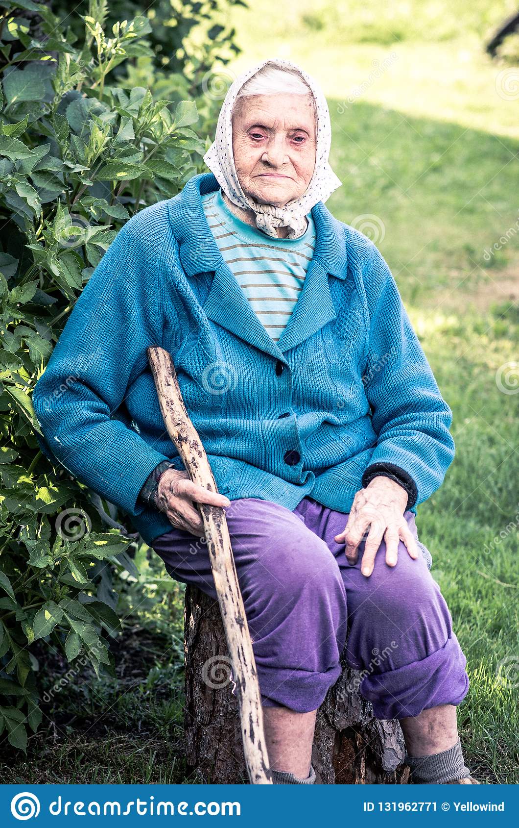 senior-woman-sitting-log-holding-long-cane-senior-woman-sitting-log-holding-long-cane-countryside-village-people-131962771